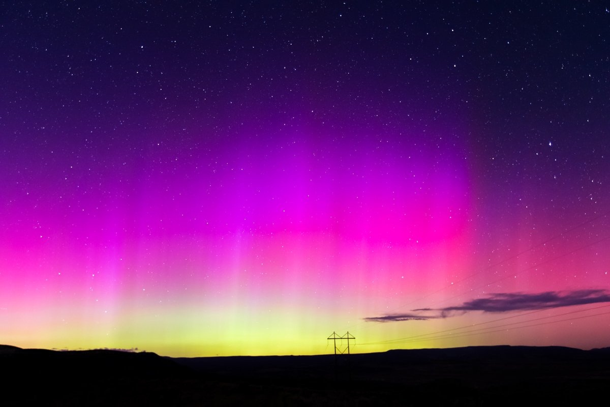 Vibrant pink/purple hues from the Aurora Borealis ( Northern Lights ) light up the night sky on May 11, 2024