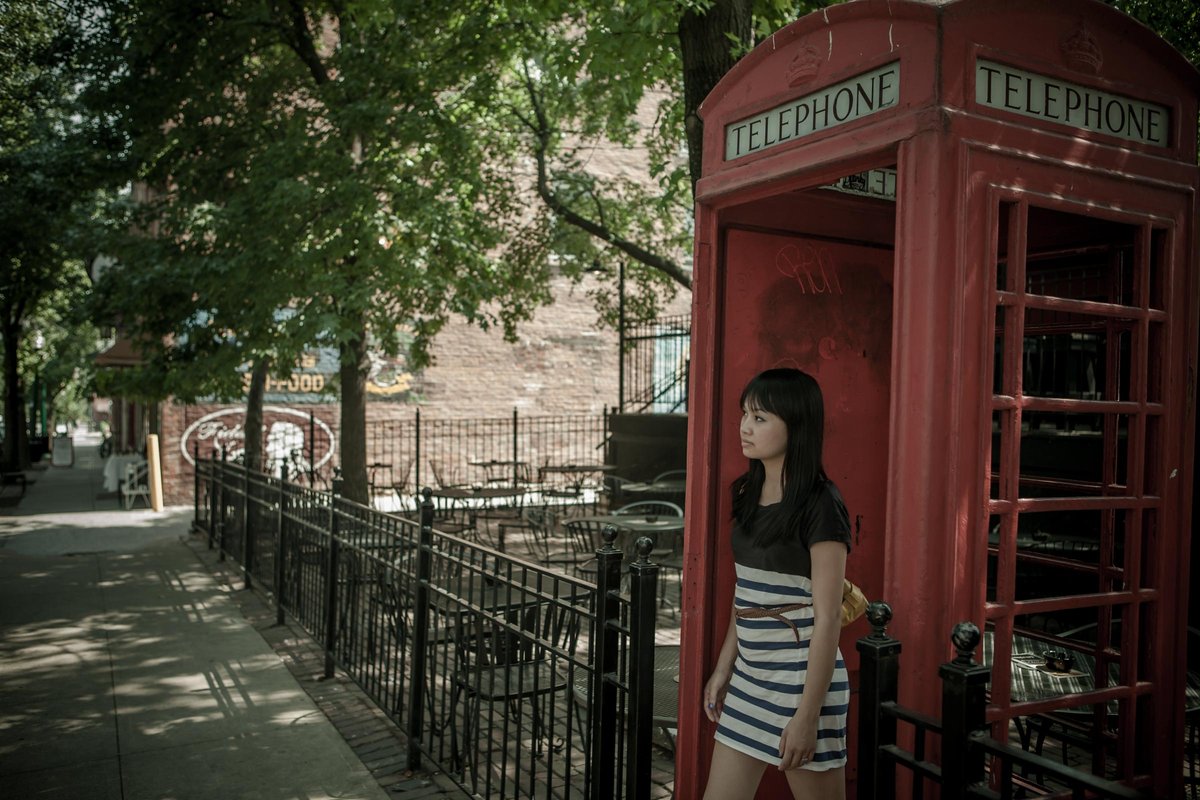 Lily Le in a phone booth on the streets in Kansas City